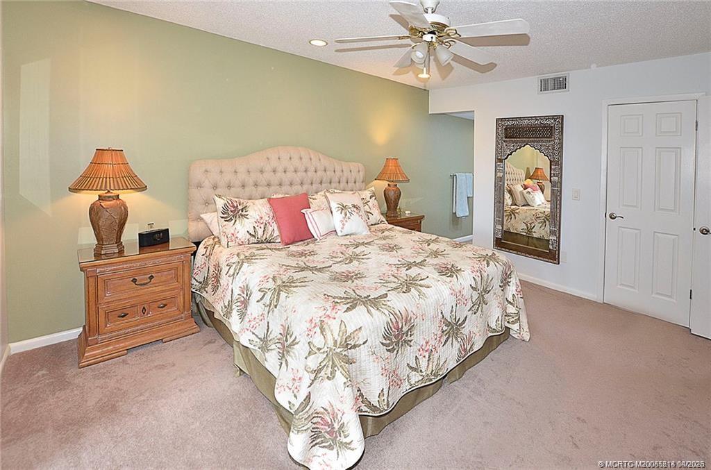 1854 Southwest Palm City Road, Unit 203 Stuart, FL 34994 - Photo 24 of 38 a bedroom with a bed and a chandelier