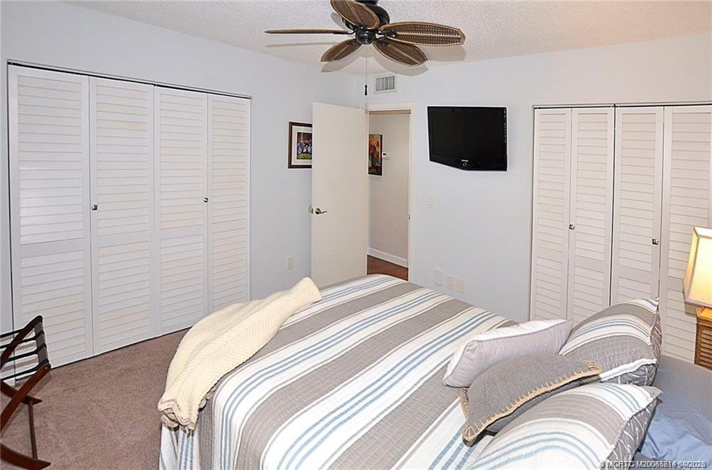 1854 Southwest Palm City Road, Unit 203 Stuart, FL 34994 - Photo 27 of 38 a bedroom with a bed and a flat screen tv