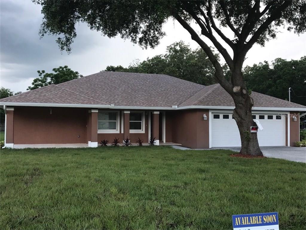 a front view of a house with a garden and trees