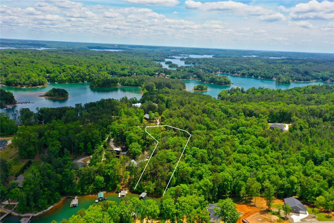 Lot 114 Harbor Point Seneca, SC 29672 - Photo 2 of 46 This aerial view showcases a vibrant lake and lush forested landscape.
