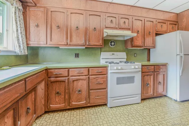 a kitchen with stainless steel appliances granite countertop a sink a stove cabinets counter space and a window