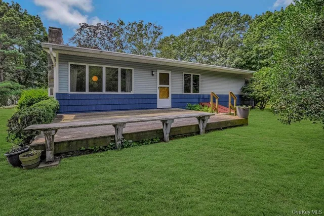 a view of a house with a backyard and chairs