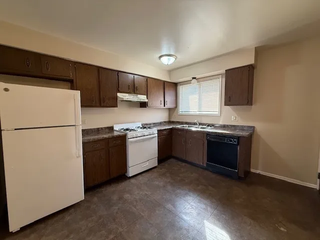 a kitchen with stainless steel appliances granite countertop a refrigerator sink and stove