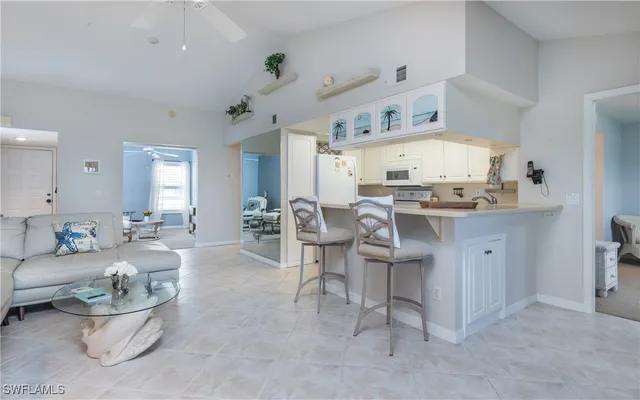 a kitchen with stainless steel appliances a white table chairs and a refrigerator