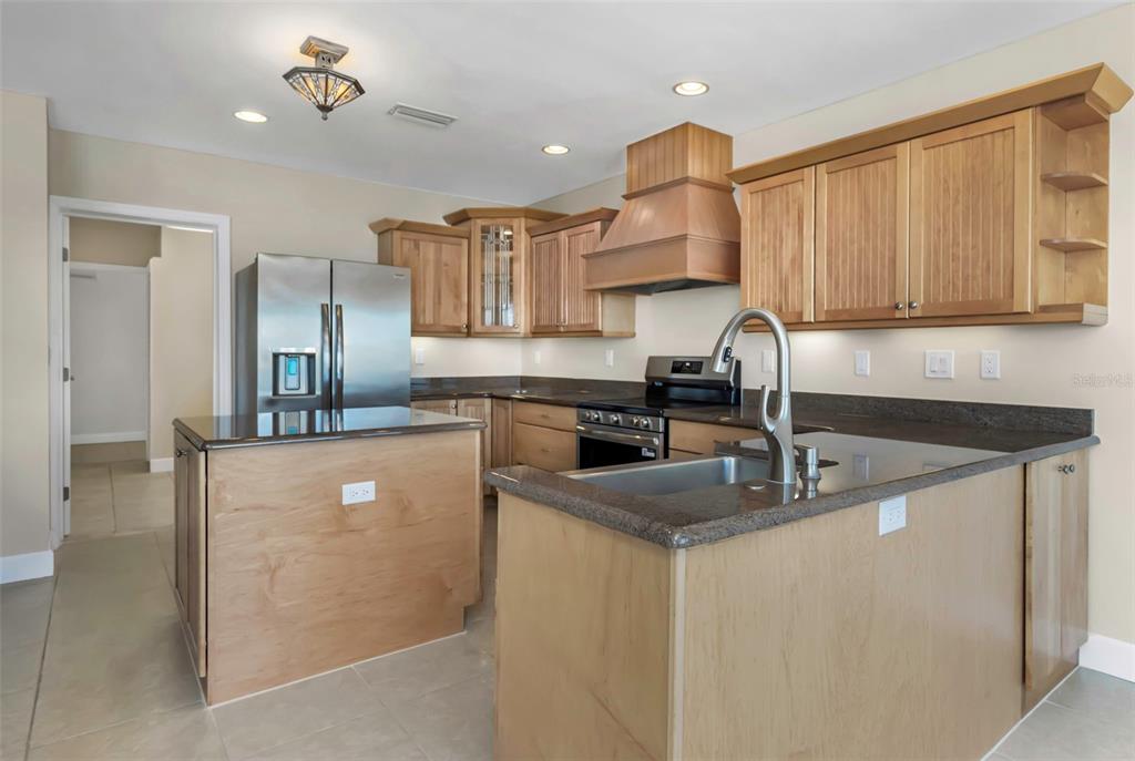 1445 Corey Way South South Pasadena, FL 33707 - Photo 17 of 61 a kitchen with granite countertop a sink a stove and cabinets