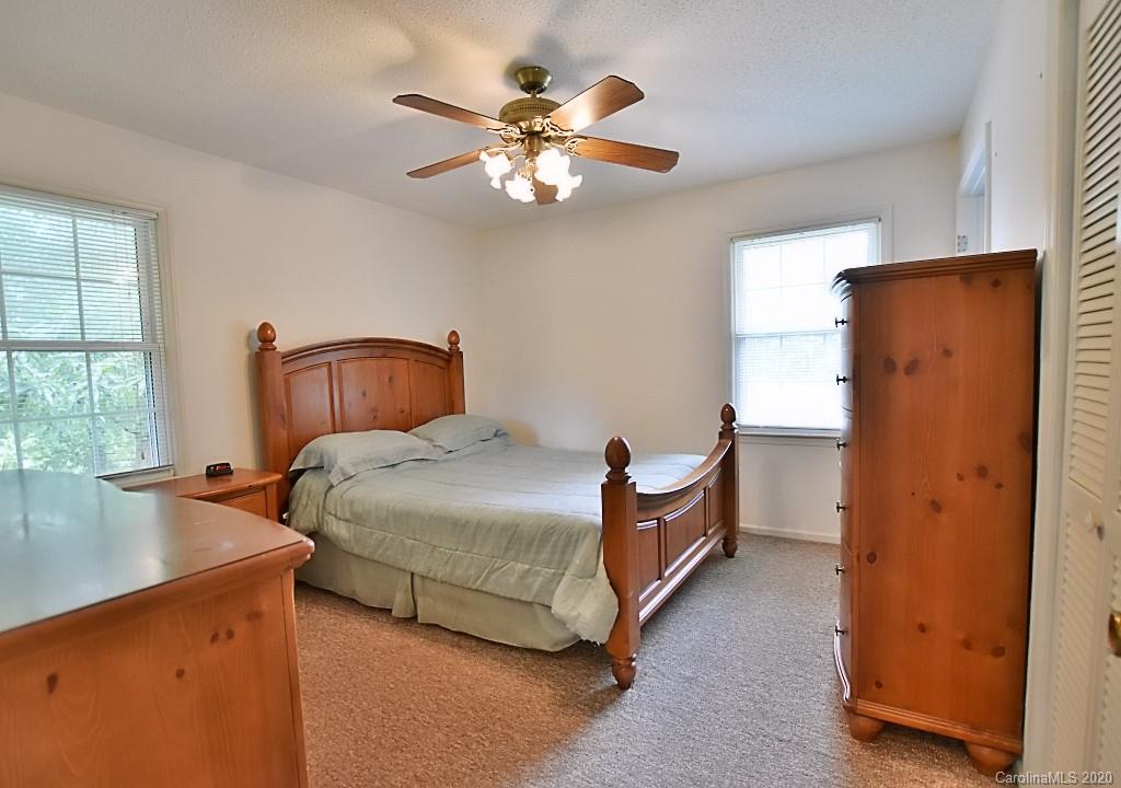 8940 Collins Road Indian Land, SC 29707 - Photo 14 of 28 a bedroom with a bed and a chandelier
