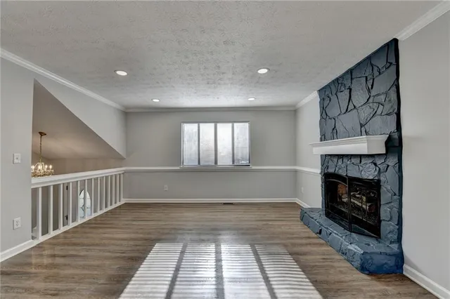 a view of empty room with wooden floor and window