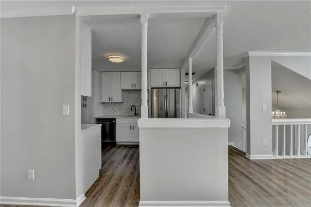a kitchen with stainless steel appliances granite countertop white cabinets granite counter tops and a window