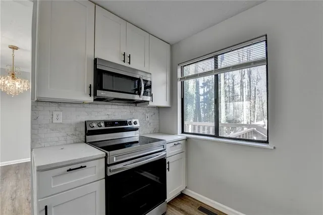 a large kitchen with cabinets and a wooden floor