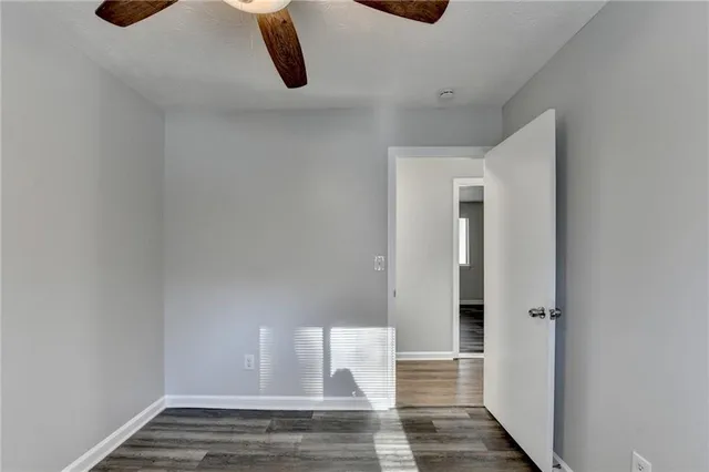 a view of a hallway with a chandelier fan and wooden floor