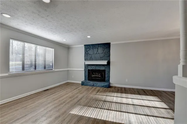 a view of an empty room with a fireplace and window