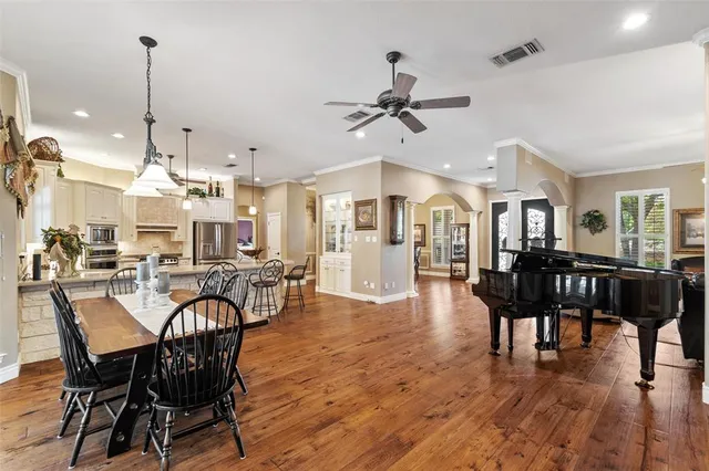 a view of a dining room and livingroom with furniture wooden floor a chandelier