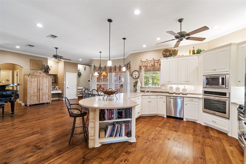 102 Ridge Court Glen Rose, TX 76043 - Photo 12 of 39 a kitchen with stainless steel appliances a dining table chairs stove and wooden floor