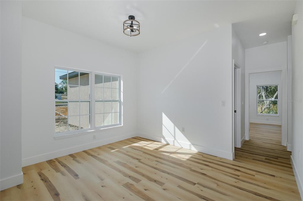 11277 Fool Duck Avenue Weeki Wachee, FL 34613 - Photo 51 of 75 a view of empty room with wooden floor and fan