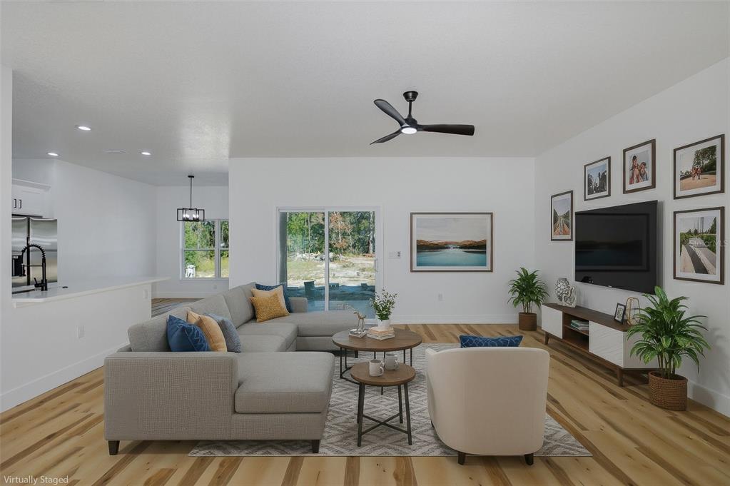 11277 Fool Duck Avenue Weeki Wachee, FL 34613 - Photo 6 of 75 a living room with furniture a flat screen tv and a large window