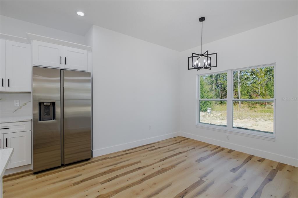 11277 Fool Duck Avenue Weeki Wachee, FL 34613 - Photo 61 of 75 a view of a kitchen with a ceiling fan wooden floor and a window