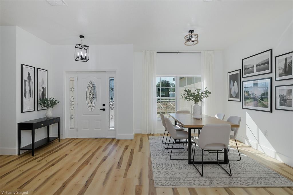 11277 Fool Duck Avenue Weeki Wachee, FL 34613 - Photo 7 of 75 a view of a dining room with furniture and wooden floor