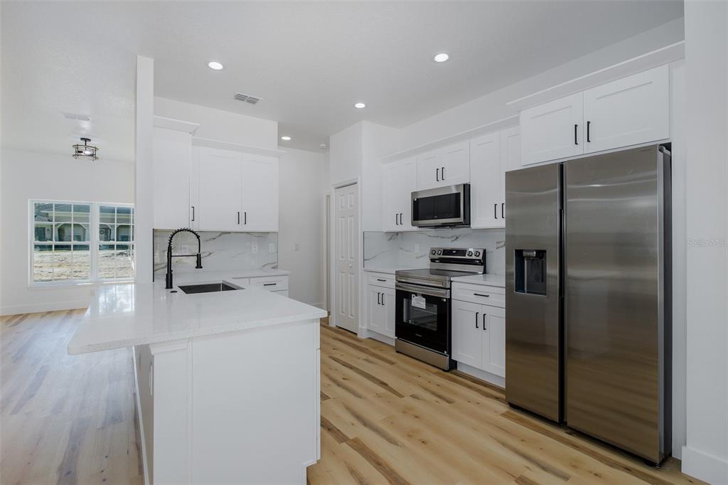 11277 Fool Duck Avenue Weeki Wachee, FL 34613 - Photo 9 of 75 a kitchen with a refrigerator sink and stainless steel appliances