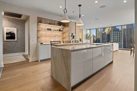a large kitchen with kitchen island a large counter top space a sink stainless steel appliances and cabinets