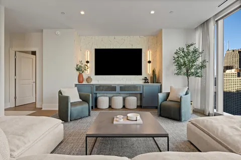 a living room with furniture and a view of kitchen