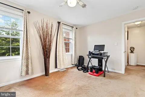 a view of a livingroom with workspace and windows