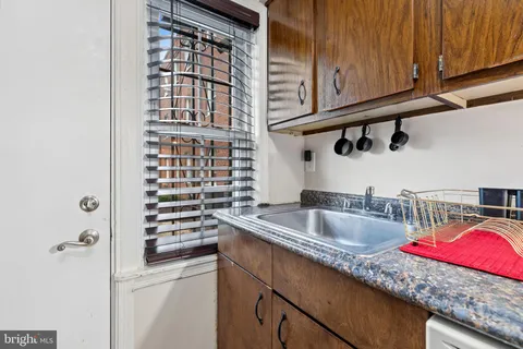 a kitchen with granite countertop a sink and a wooden cabinets