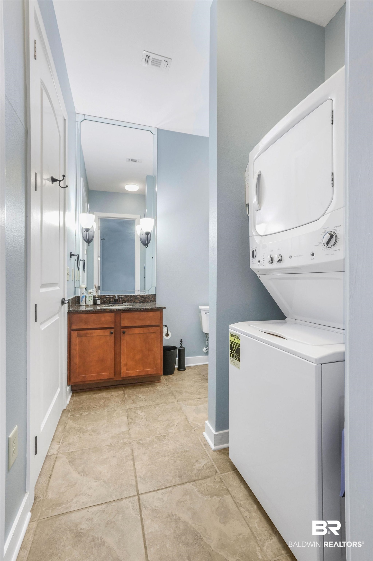 1430 Regency Road, Unit B302 Gulf Shores, AL 36542 - Photo 15 of 24 Clothes washing area with laundry area, baseboards, visible vents, and stacked washing maching and dryer
