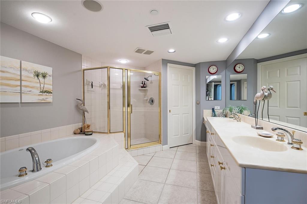 7117 Pelican Bay Boulevard, Unit 206 Naples, FL 34108 - Photo 11 of 35 a spacious bathroom with a bathtub shower sink and mirror