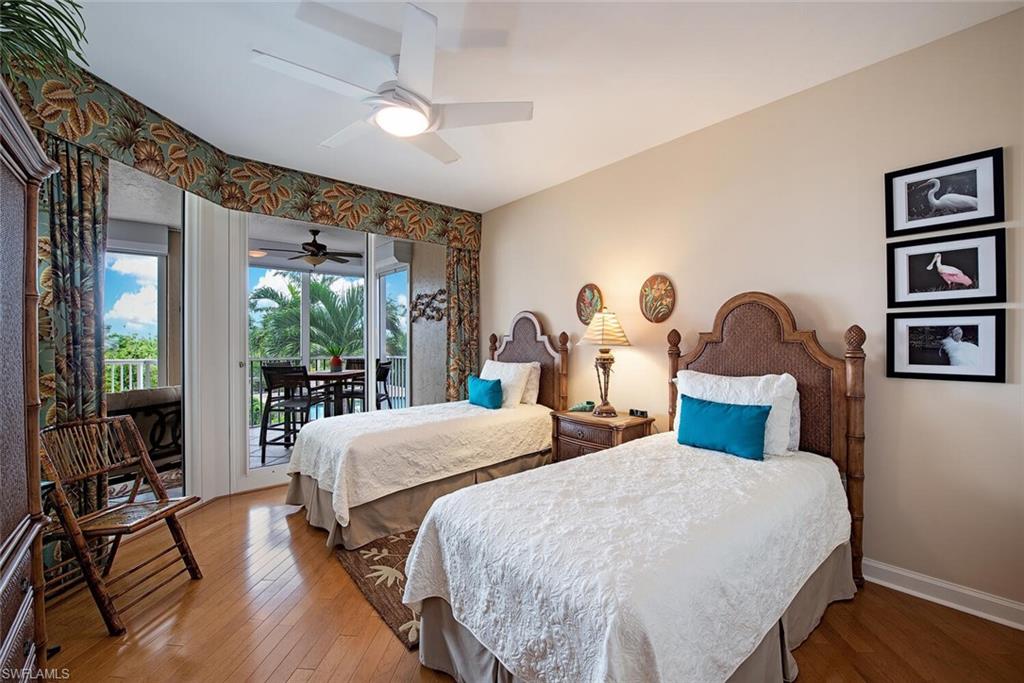 7117 Pelican Bay Boulevard, Unit 206 Naples, FL 34108 - Photo 12 of 35 a bedroom with two beds and a large window