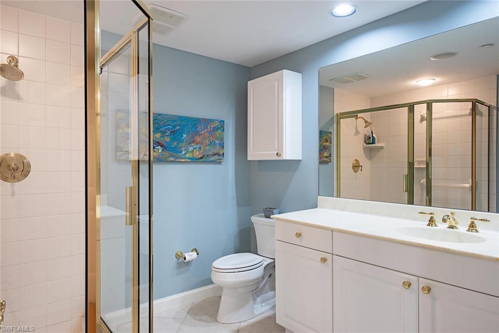7117 Pelican Bay Boulevard, Unit 206 Naples, FL 34108 - Photo 13 of 35 a bathroom with a toilet a sink and a mirror