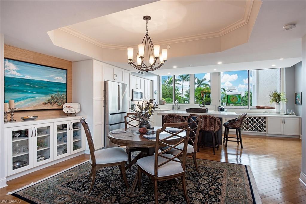 7117 Pelican Bay Boulevard, Unit 206 Naples, FL 34108 - Photo 2 of 35 a view of a dining room with furniture window and wooden floor