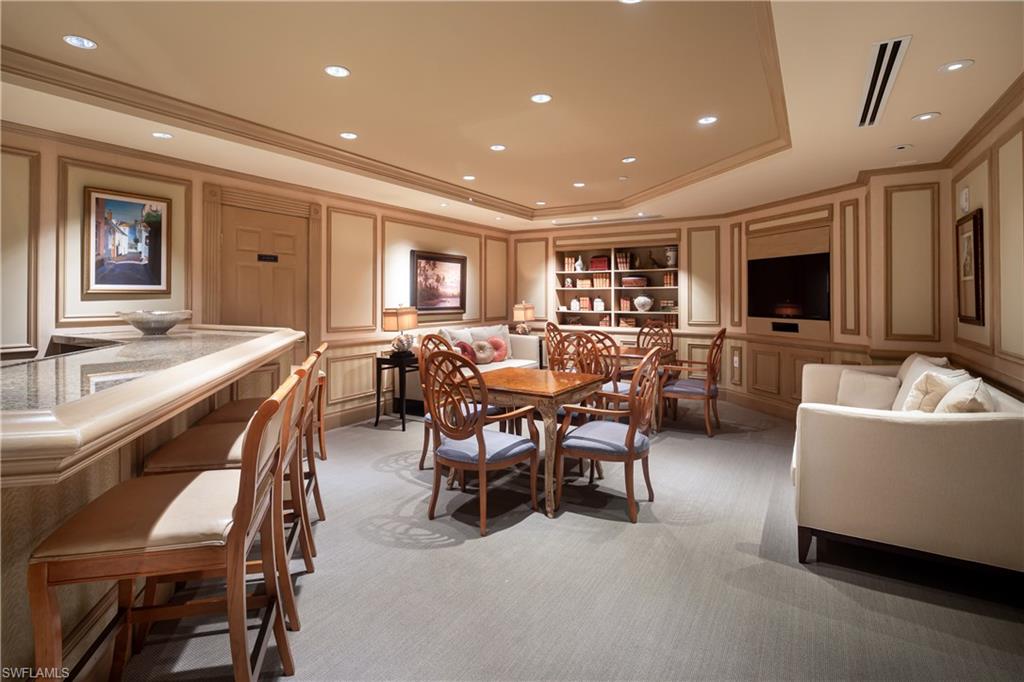 7117 Pelican Bay Boulevard, Unit 206 Naples, FL 34108 - Photo 21 of 35 a living room with furniture and a flat screen tv