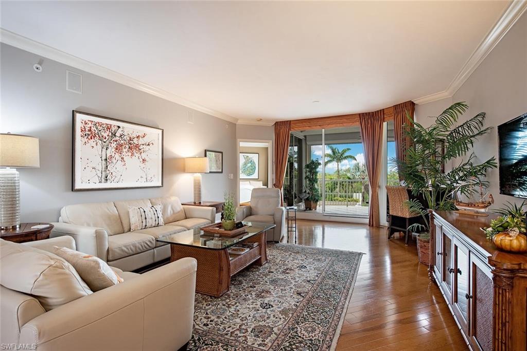 7117 Pelican Bay Boulevard, Unit 206 Naples, FL 34108 - Photo 6 of 35 a living room with furniture tv and a window