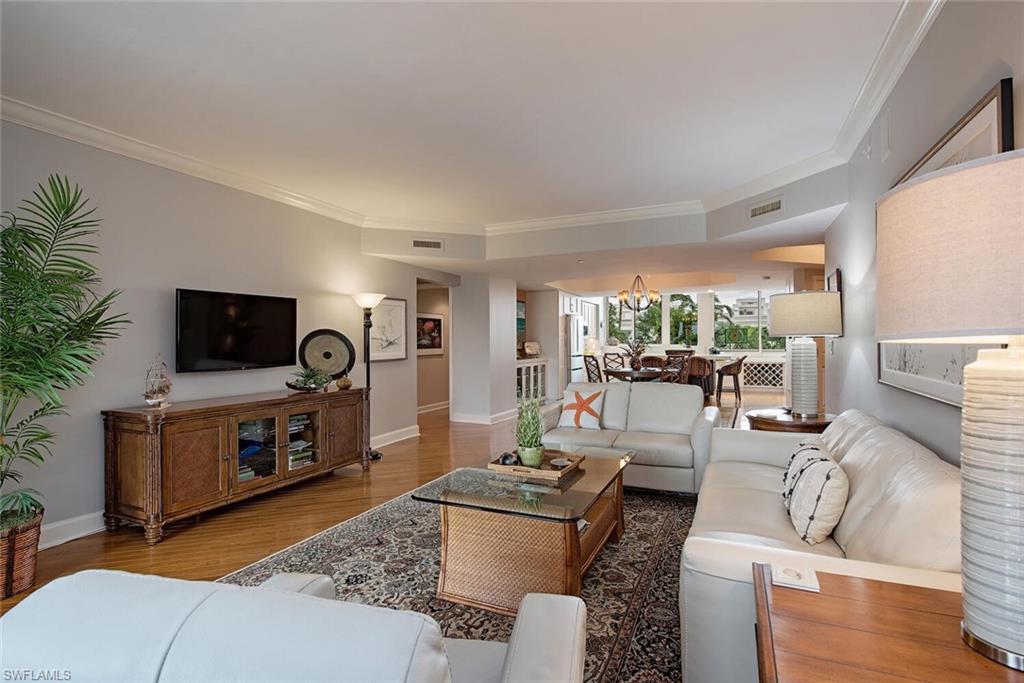 7117 Pelican Bay Boulevard, Unit 206 Naples, FL 34108 - Photo 7 of 35 a living room with furniture and a flat screen tv