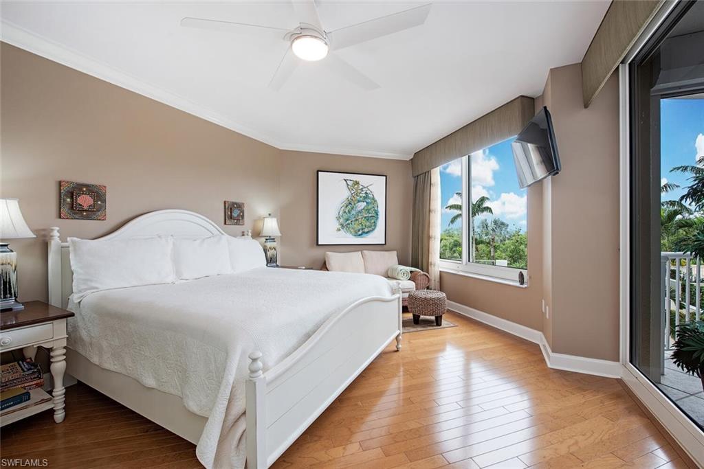 7117 Pelican Bay Boulevard, Unit 206 Naples, FL 34108 - Photo 10 of 35 a bedroom with a bed and a large window