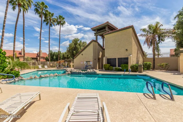 a view of a house with a yard and palm trees