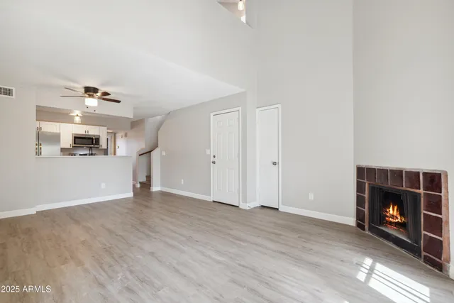 a view of a livingroom with wooden floor and a fireplace