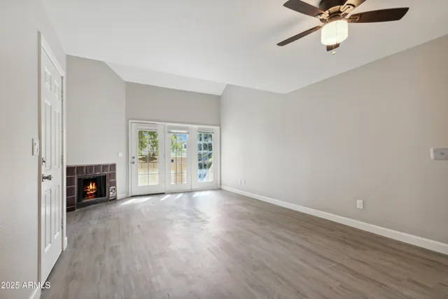 a view of an empty room with a fireplace and a window