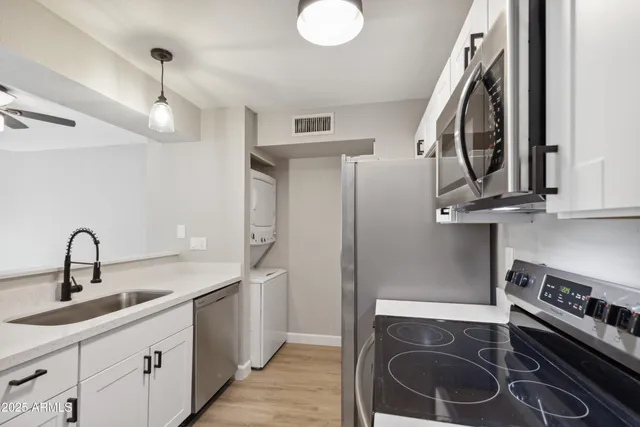 a kitchen with stainless steel appliances a stove a sink and a refrigerator