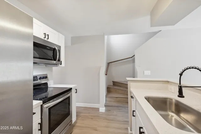 a kitchen with a sink stove and microwave