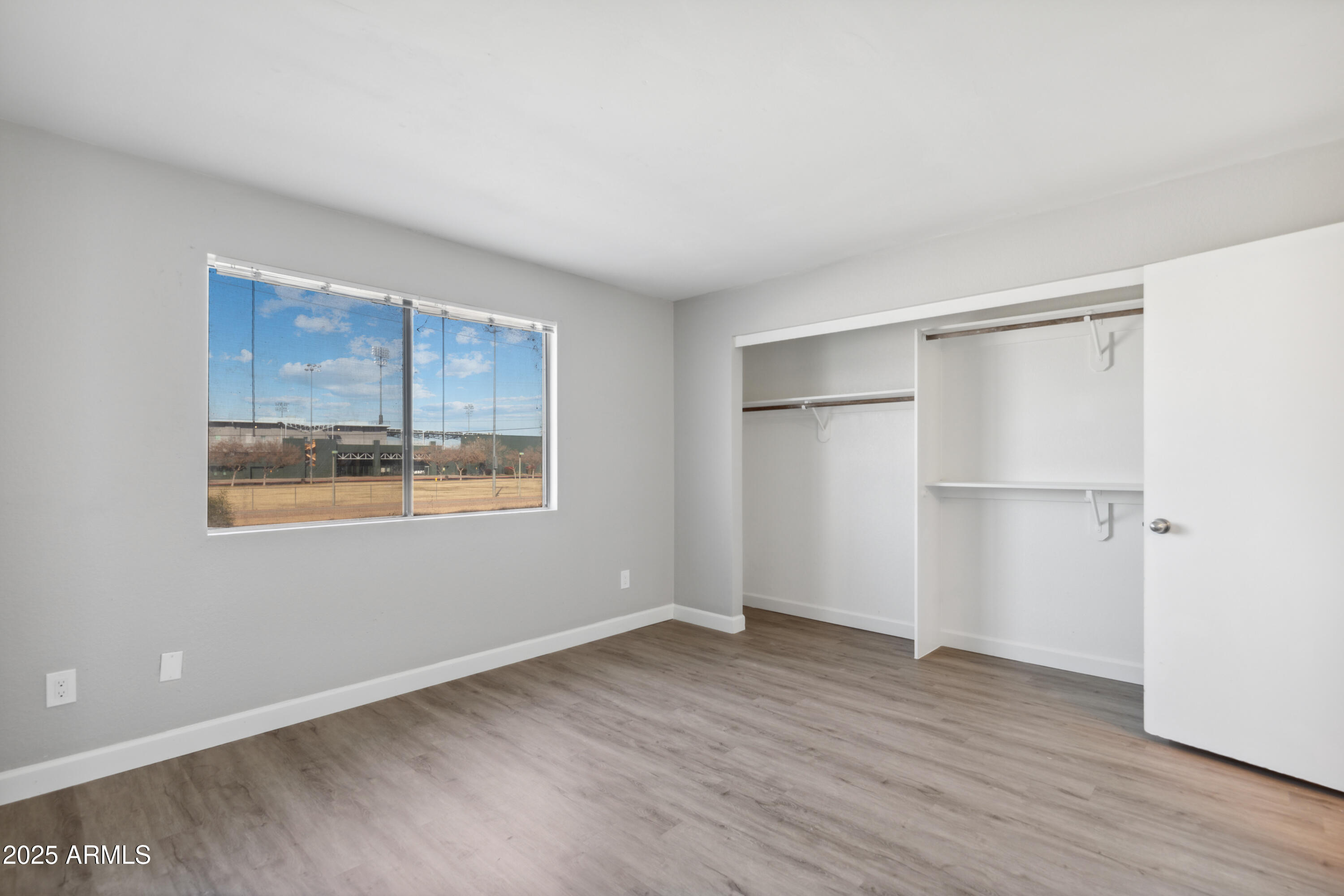 30 East Brown Road, Unit 2081 Mesa, AZ 85201 - Photo 7 of 19 a view of an empty room with wooden floor and a window