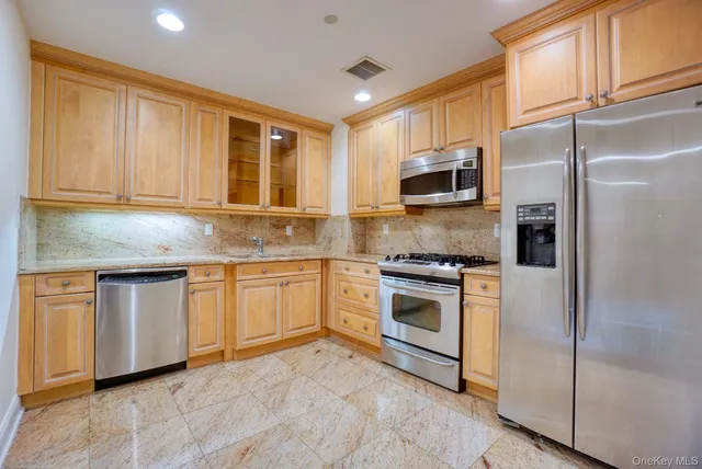 a kitchen with granite countertop cabinets stainless steel appliances and a window