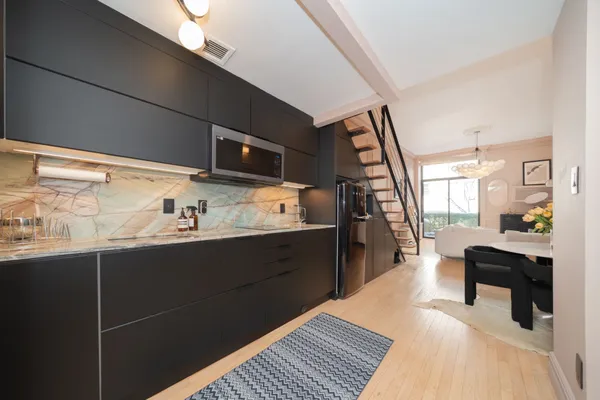 a kitchen with stainless steel appliances kitchen island granite countertop a refrigerator and a sink
