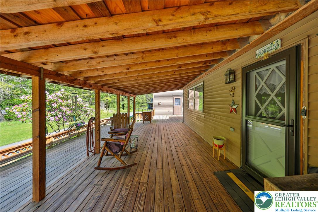 331 Cranberry Creek Road Cresco, PA 18326 - Photo 84 of 95 An inviting covered deck extends the living space outdoors, offering serene views of surrounding greenery.