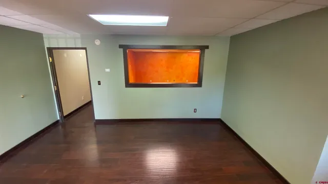 an empty room with wooden floor and a window