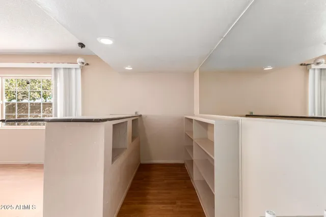 an empty room with a window and a fan