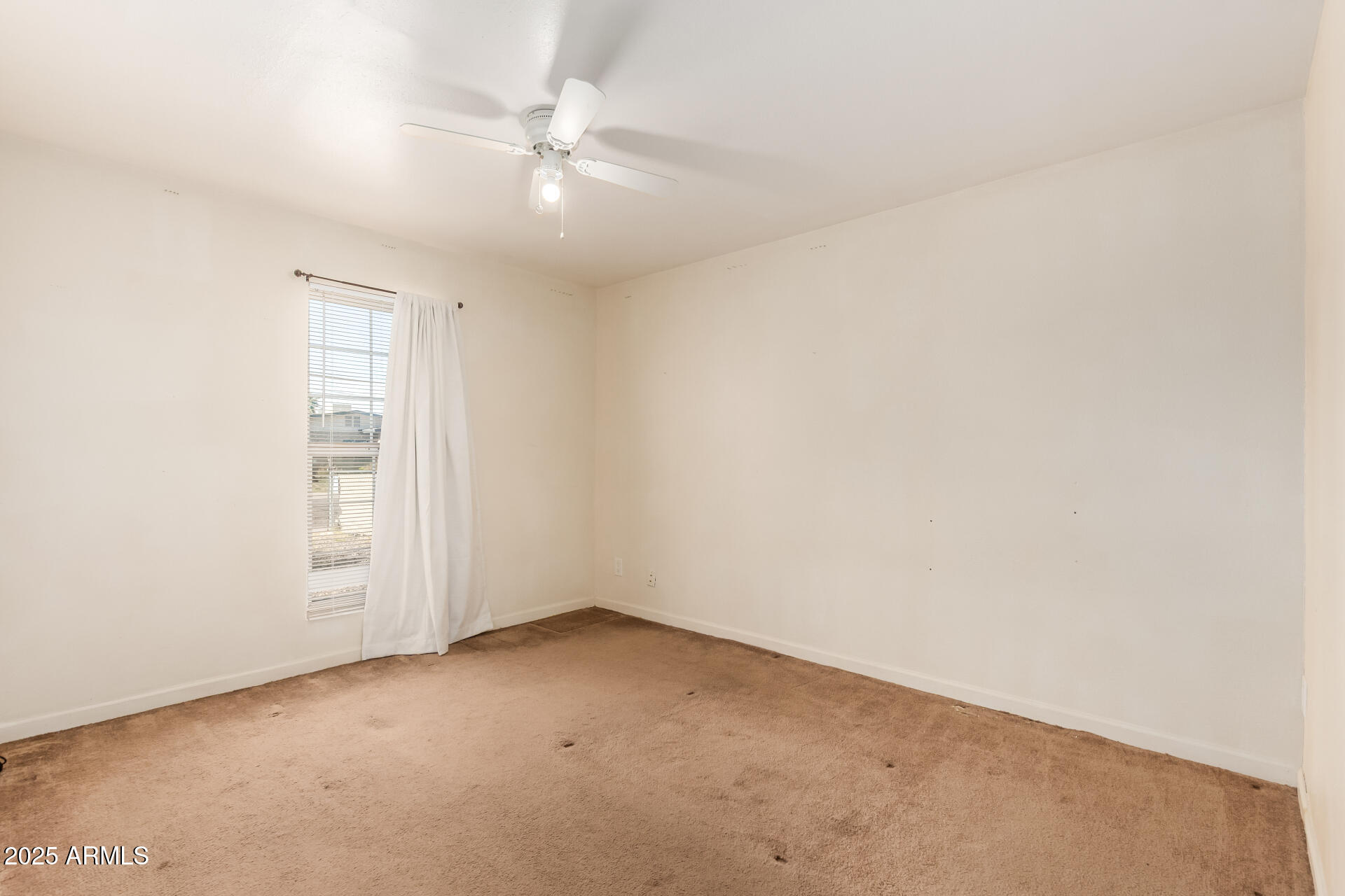3251 West Cortez Avenue Phoenix, AZ 85029 - Photo 20 of 32 an empty room with a window and a ceiling fan