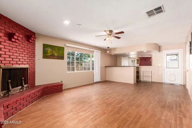 a view of an empty room with a window and a kitchen