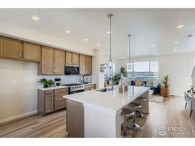 a kitchen with stainless steel appliances kitchen island granite countertop a stove a sink and a refrigerator