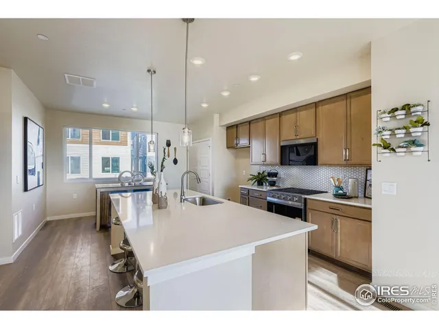 a kitchen with stainless steel appliances a stove a sink a microwave a center island and cabinets